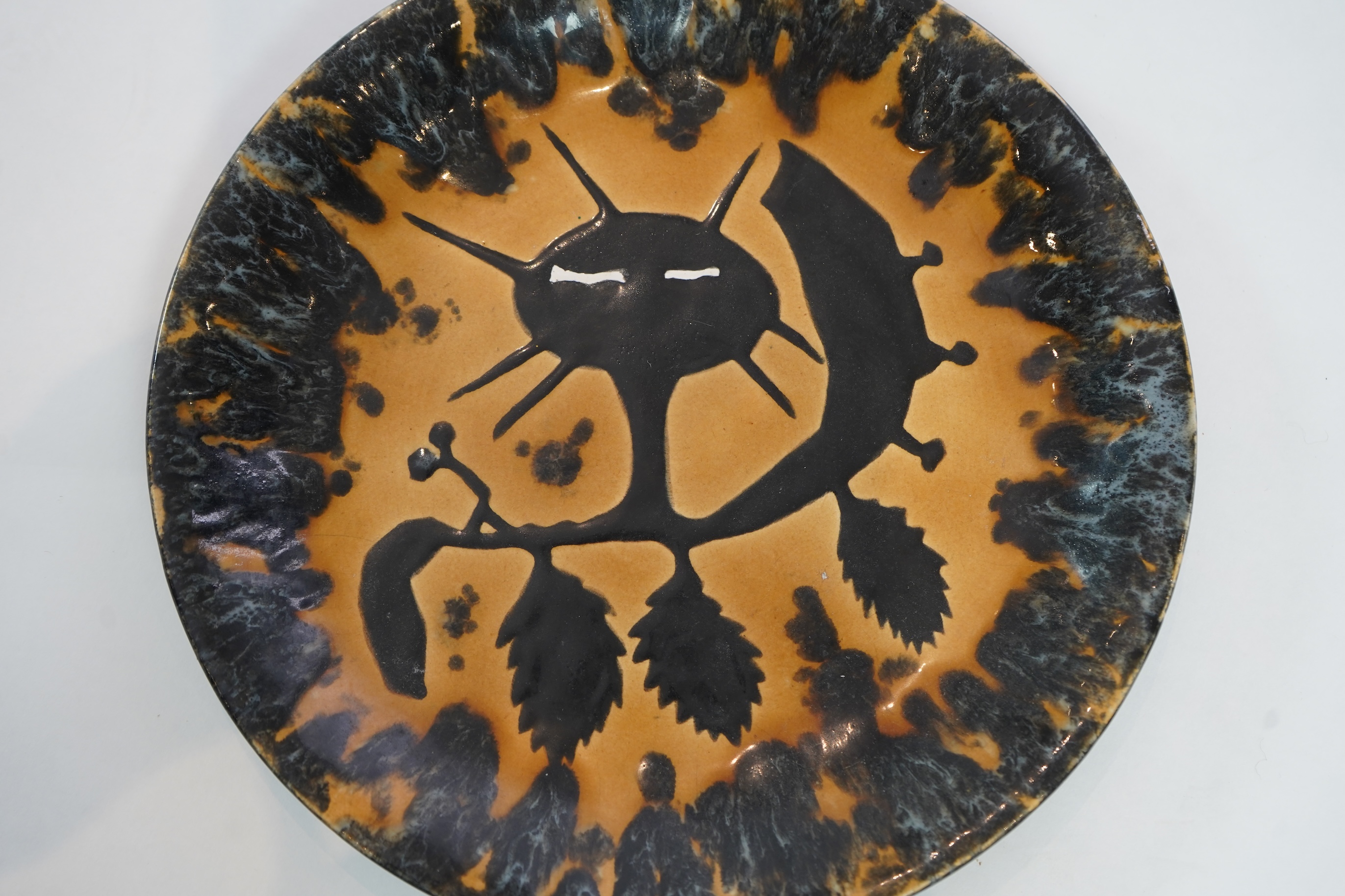 Jean Lurçat (1892-1966): An ochre and black glazed earthenware plate, decorated with a stylised central figure